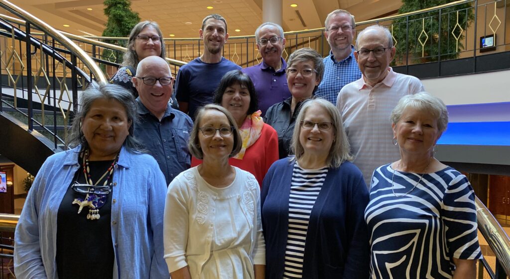 MC USA Executive Board members in three lines posing on a circular staircase.